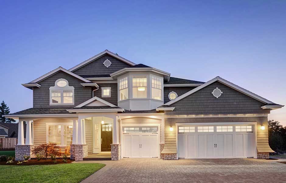 Modern two-story home at dusk with lights on